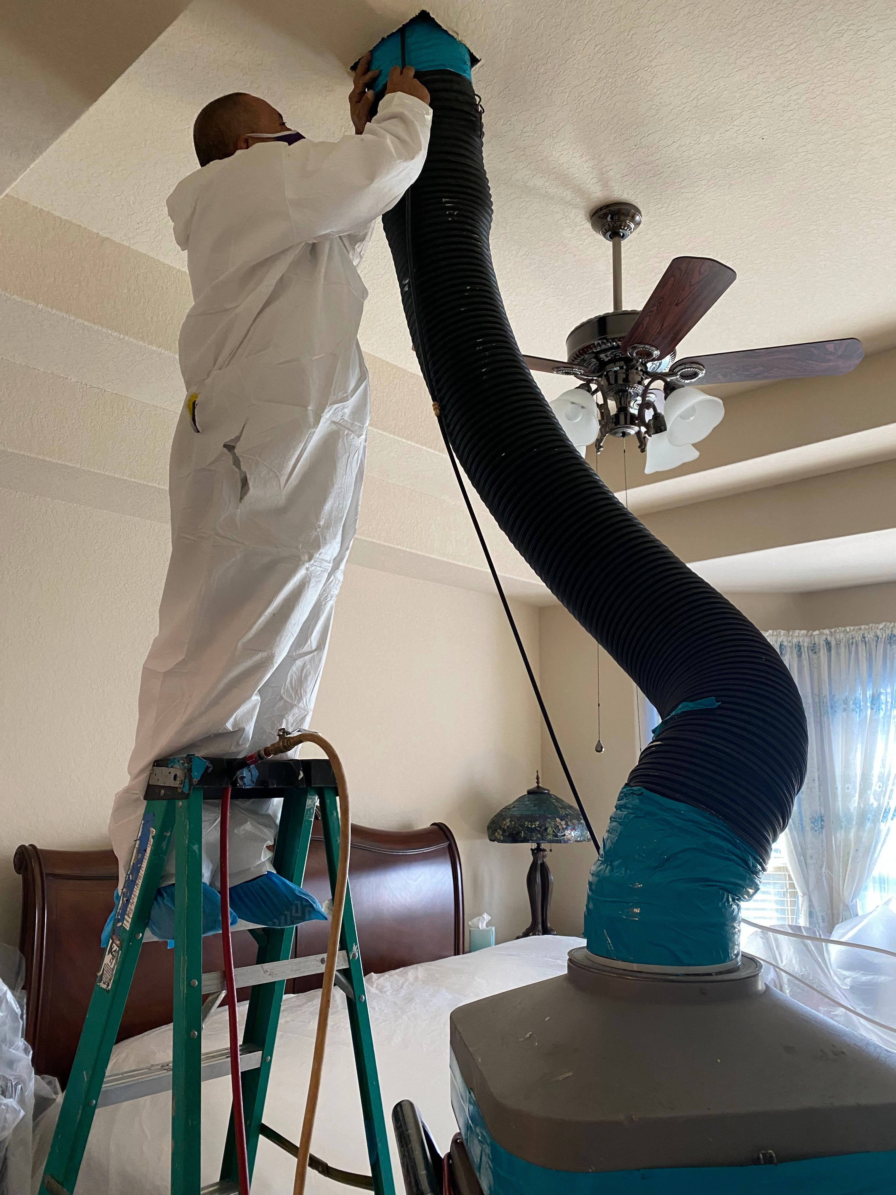 A man cleaning a room with a vacuum.