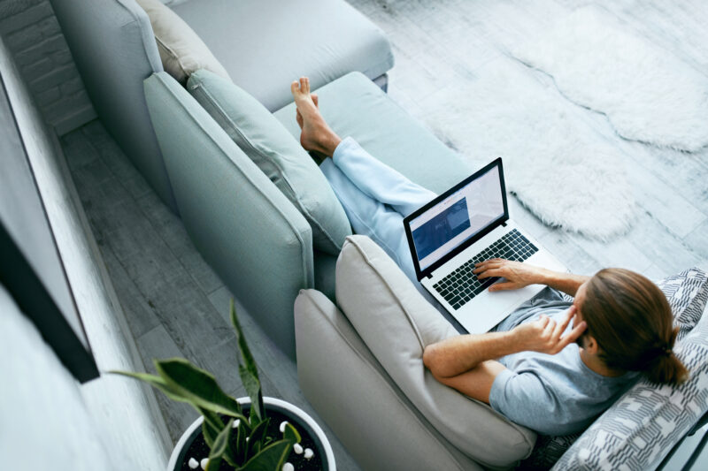 A person sitting on the couch with a laptop